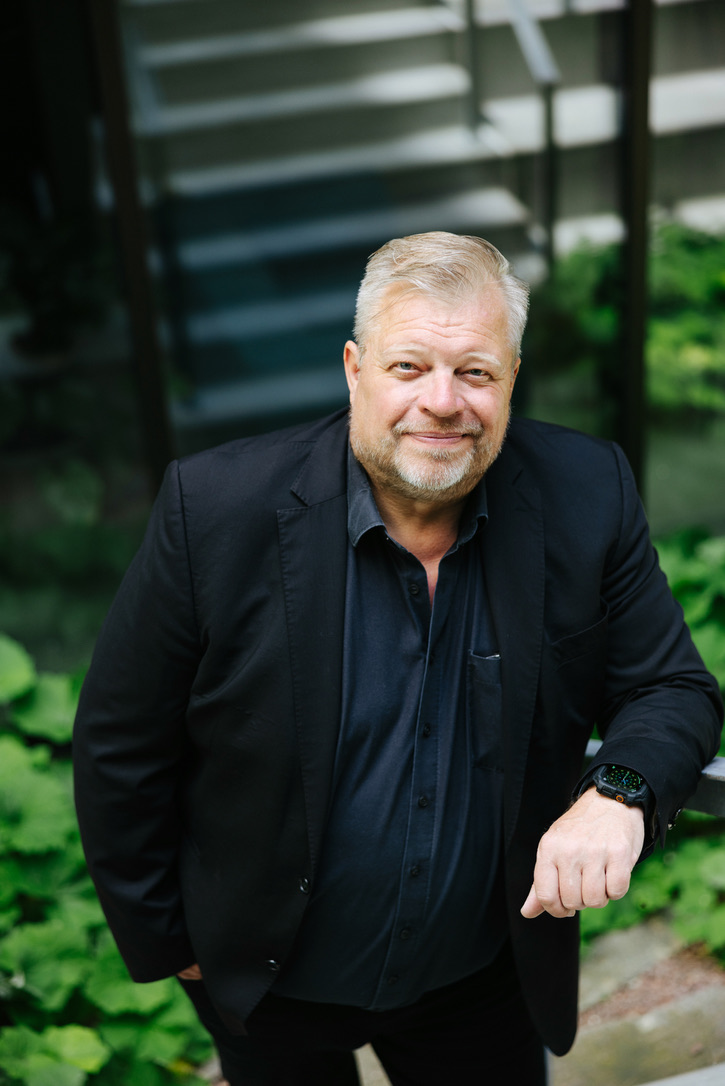 Henrik Stender ved en trappe omgivet af grønne planter